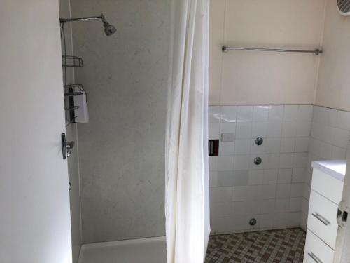 a bathroom with a shower with a shower curtain at Highlander Van Village in Armidale