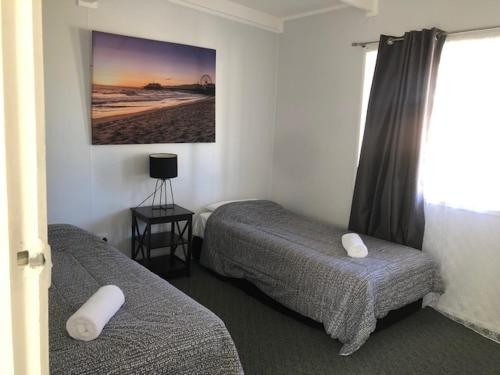 a hotel room with two beds and a window at Highlander Van Village in Armidale