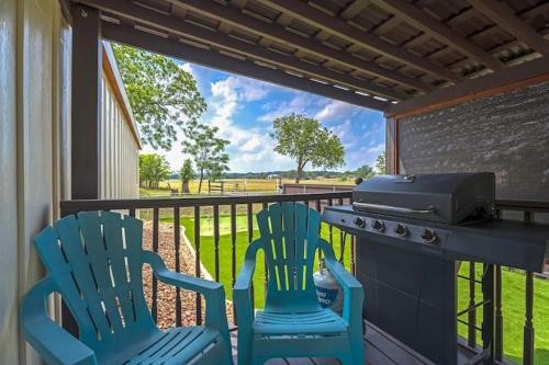 two blue chairs and a grill on a porch at Bella’s BnB in Comfort