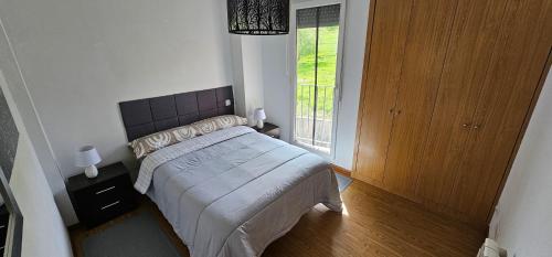 1 dormitorio con cama y ventana grande en Nuevo Apartamento Vacacional en Cantabria, en Renedo de Piélagos