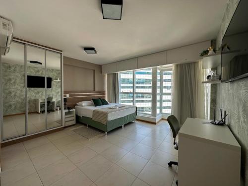 a bedroom with a bed and a desk in it at Flat Saint Moritz Brasília Hotel in Brasilia