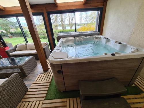 un grand bain à remous dans le salon dans l'établissement Grande Maison au Bord d'un Lac avec Spa, Jardin Clôturé et Proche du ZooParc de Beauval - FR-1-591-336, à Luçay-le-Mâle