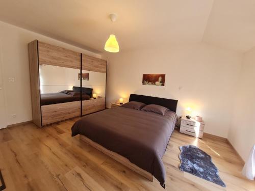 ein Schlafzimmer mit einem großen Bett und einem großen Spiegel in der Unterkunft Gîte Montmédy, 3 pièces, 6 personnes - FR-1-585-78 in Montmédy