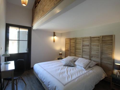 1 dormitorio con 1 cama blanca grande y cabecero de madera en Gîte Lys-Haut-Layon, 3 pièces, 6 personnes - FR-1-622-30, en Vihiers