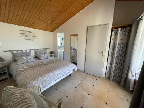 sypialnia z łóżkiem i drewnianym sufitem w obiekcie Maison climatisée, 2 gîtes, 2 chambres, 15 hectares, loisirs, animaux acceptés - FR-1-426-520 w mieście Bouin