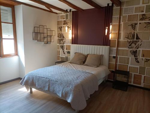 Schlafzimmer mit einem Bett und einer Wand mit Bildern in der Unterkunft Gîte Bruère-Allichamps, 6 pièces, 10 personnes - FR-1-586-26 in Bruère-Allichamps