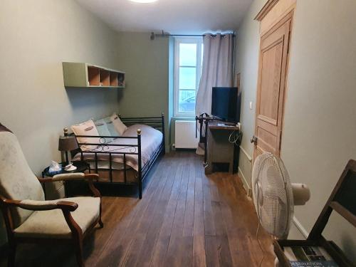 a bedroom with a bed and a chair and a window at Escapade de charme près de Verdun : cocon pour 2 personnes avec cuisine équipée et balades à proximité - FR-1-585-85 in Souilly