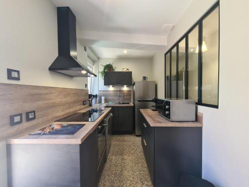 une cuisine avec un comptoir et un réfrigérateur dans l'établissement Maison confortable près des Châteaux de la Loire et Zoo de Beauval avec cour et parking privé - FR-1-591-367, à Chabris