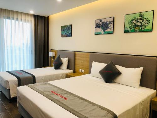 a hotel room with two beds and a window at Hanvet Hotel Do Son in Ðố Sơn