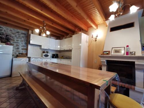 a large kitchen with a large wooden counter top at Charmant gîte historique avec pêche privée et forêt, près de Brioude et Blesle - FR-1-582-352 in Lorlanges