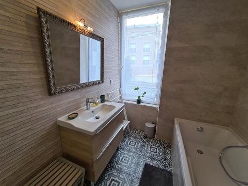 ein Badezimmer mit einem Waschbecken, einem Spiegel und einer Badewanne in der Unterkunft Gîte Artenay, 5 pièces, 10 personnes - FR-1-590-255 in Artenay