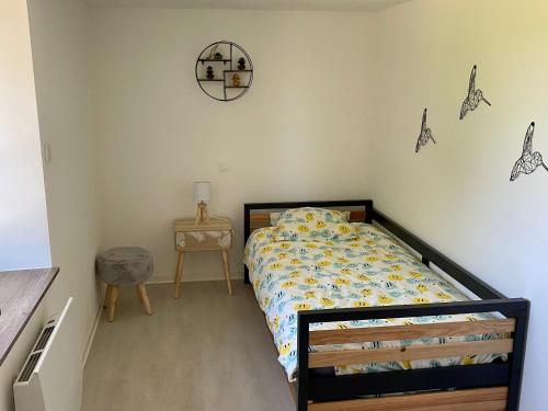 a bedroom with a bed and a clock on the wall at Gîte de charme avec sauna, spa et terrain de pétanque à Plombières-les-Bains, idéal en famille - FR-1-589-432 in Plombières-les-Bains