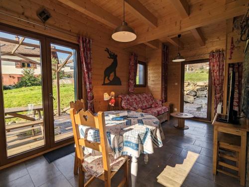 une salle à manger avec une table et un canapé dans l'établissement Chalet neuf à Gérardmer avec terrasse et parking privé - FR-1-589-465, à Gérardmer