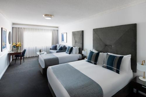 um quarto de hotel com duas camas e um sofá em Peppers The Hills Lodge em Castle Hill