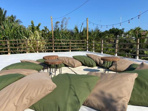 a group of pillows and chairs on a patio at Amor Rooms in Tulum