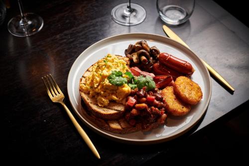 a plate of breakfast food with scrambled eggs and sausage at Novotel Melbourne Glen Waverley in Glen Waverley