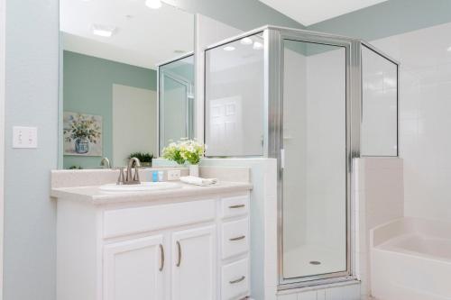 a white bathroom with a sink and a shower at Our Happy Place in Kissimmee
