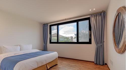 a bedroom with a bed and a large window at Olle Resort in Jeju