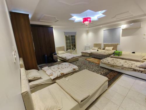 a large living room with couches and a chandelier at Fatih Hostel for Males in ‘Urwah
