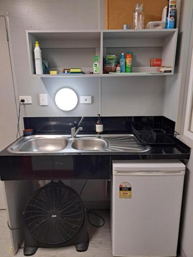 a small kitchen with a sink and a fan at Cooktown Fishing Haven in Cooktown