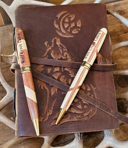 a group of three pens sitting on top of a book at Wolf Creek Luxury Cabin in Broken Bow