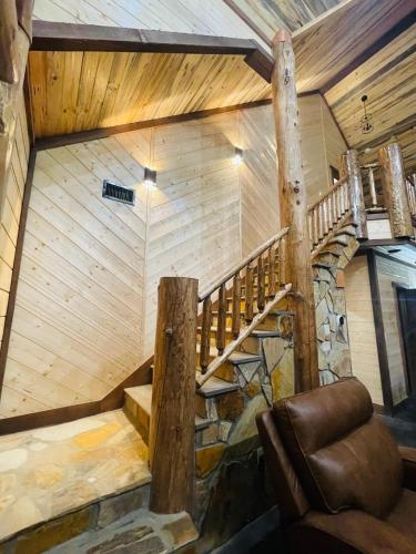 a room with a wooden staircase in a house at Wolf Creek Luxury Cabin in Broken Bow