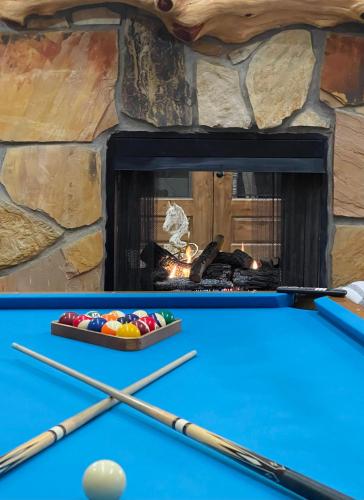 a pool table in front of a fireplace at Wolf Creek Luxury Cabin in Broken Bow