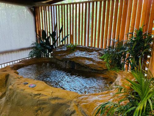 a koi pond in a garden with a wooden fence at Wolf Creek Luxury Cabin in Broken Bow