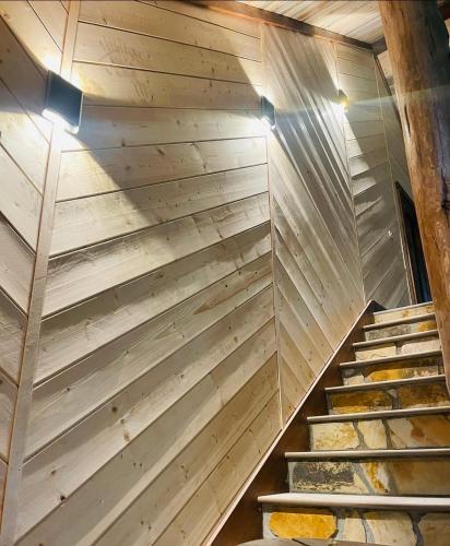a staircase in a room with wooden walls at Wolf Creek Luxury Cabin in Broken Bow