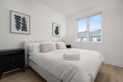 Un dormitorio blanco con una cama grande y una ventana en Cozy Townhome in Mirabel, en Mirabel