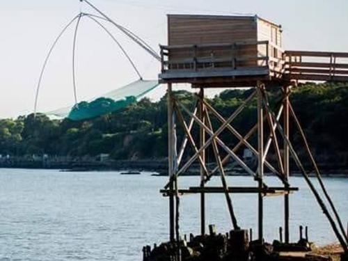 a lifeguard tower sitting on top of a body of water at Gîte Charmant en Brière: Proche Guérande, Jardin Privé, 2 Chambres - FR-1-306-941 in Saint-Lyphard