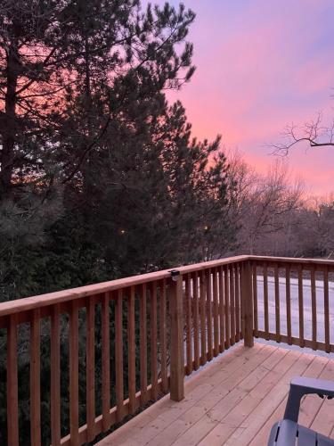 a wooden deck with a sunset in the background at Elora’s Irvine River Suite in Elora