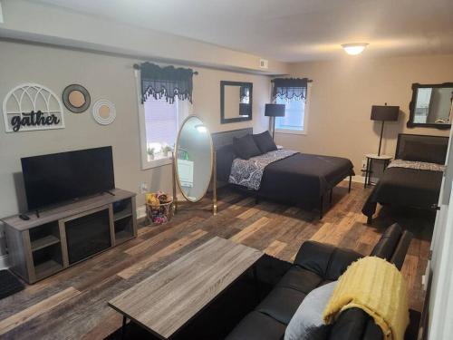 ein Wohnzimmer mit einem Bett und einem TV in der Unterkunft The Cozy Bungalow! in Poland