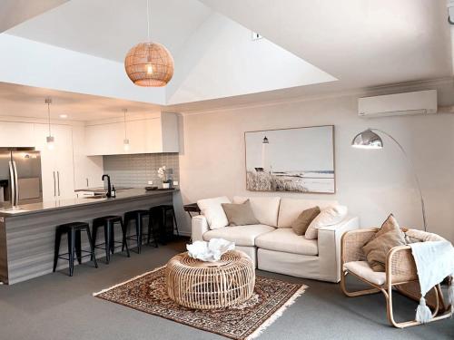 a living room with a couch and a kitchen at Sea Breeze 3 bedroom Apartment Mount Maunganui in Mount Maunganui