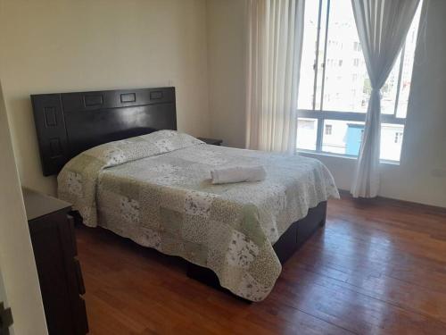 Un dormitorio con una cama con una manta. en Encantador apartamento con excelente ubicación, en Lima