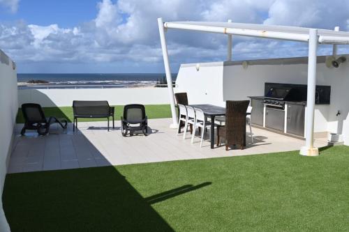a patio with a table and chairs and the beach at Waves Maroochy River in Maroochydore