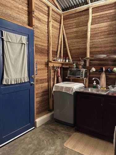 a kitchen with a sink and a blue door at La Casita de la Laguna Limón in El Cedro