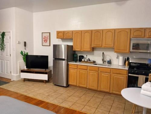 a kitchen with wooden cabinets and a stainless steel refrigerator at New Gardenroom 2 Beds (apt4) in Philadelphia