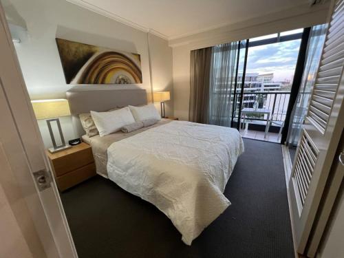 Brisbane Top Floor River Views Near Suncorp Stadium في بريزبين: غرفة نوم بسرير ونافذة كبيرة