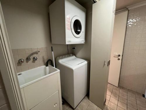 a small bathroom with a sink and a washing machine at Brisbane Top Floor River Views Near Suncorp Stadium in Brisbane