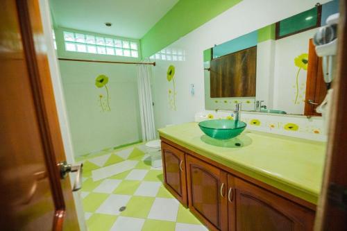 W łazience znajduje się umywalka, lustro i prysznic. w obiekcie Galápagos Trip w mieście Puerto Ayora