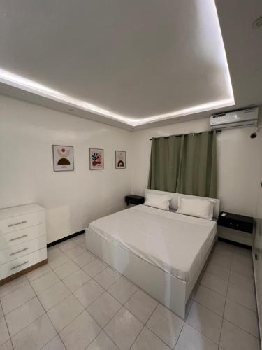 1 dormitorio con 1 cama blanca en una habitación en Le cocon by sdm en Dakar