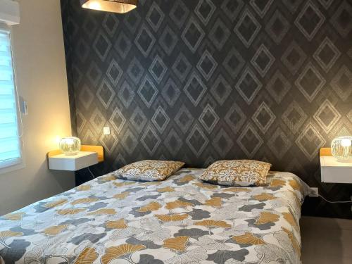 a bedroom with a bed with two pillows on it at Gîte moderne avec accès indépendant, proche centre-ville et Thermes, terrasse et équipements inclus - FR-1-589-57 in Contrexéville