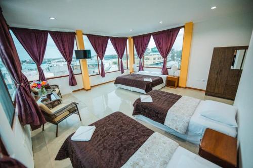 Galápagos Trip في بويرتو أيورا: غرفة فندقية بسريرين ونافذة كبيرة