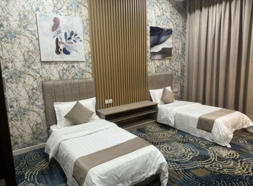 a hotel room with two beds in a room at شقق بيت المدينة للشقق المخدومة in Qabāʼ