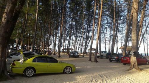 萬捷的住宿－Chalet Barokah Resort, Bachok，绿色的汽车停在一个树木繁茂的停车场