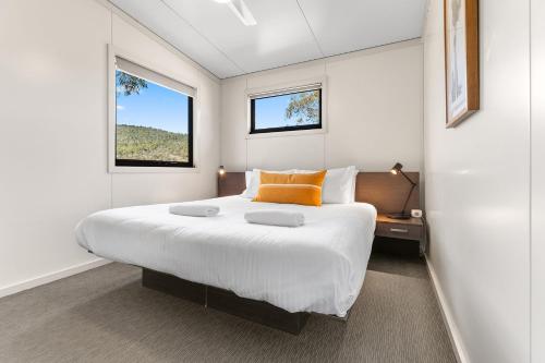 a bedroom with a large bed and a window at Ecocrackenback Chalet 18 in Crackenback