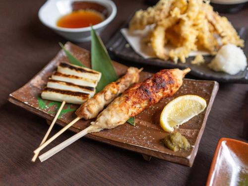 a plate of food with fish sticks and other foods at Hotel Monzennoyu in Joetsu