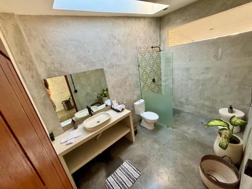 a bathroom with a sink and a toilet and a mirror at Padawatu Villas in Uluwatu