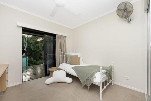 a white bedroom with a bed and a window at Luxury Style Living 20 minutes from CBD 